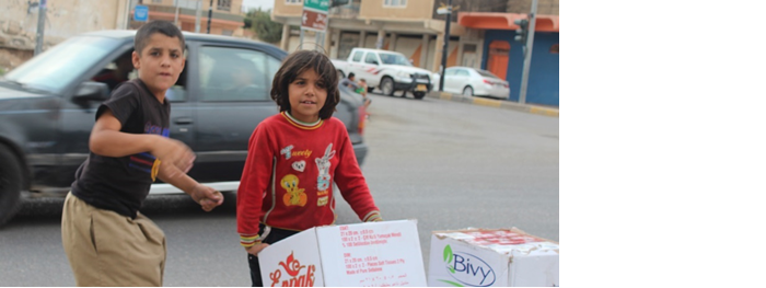 Yezidische Kinder schleppen ihre Hilfsgüter